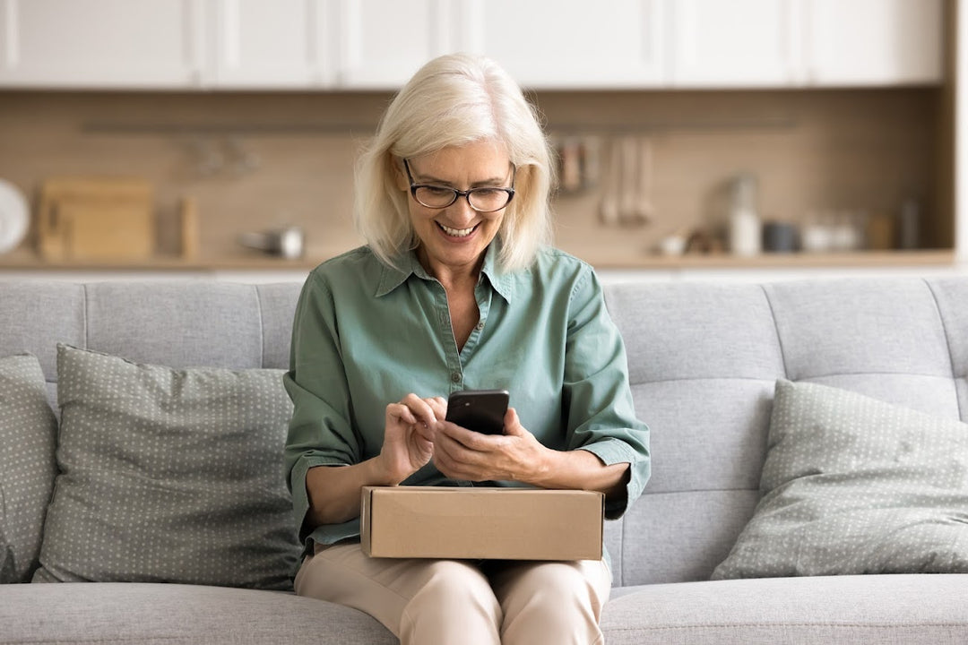 Glückliche Kundin hat ein Paket erhalten und schreibt eine positive Bewertung zum Produkt auf dem Handy