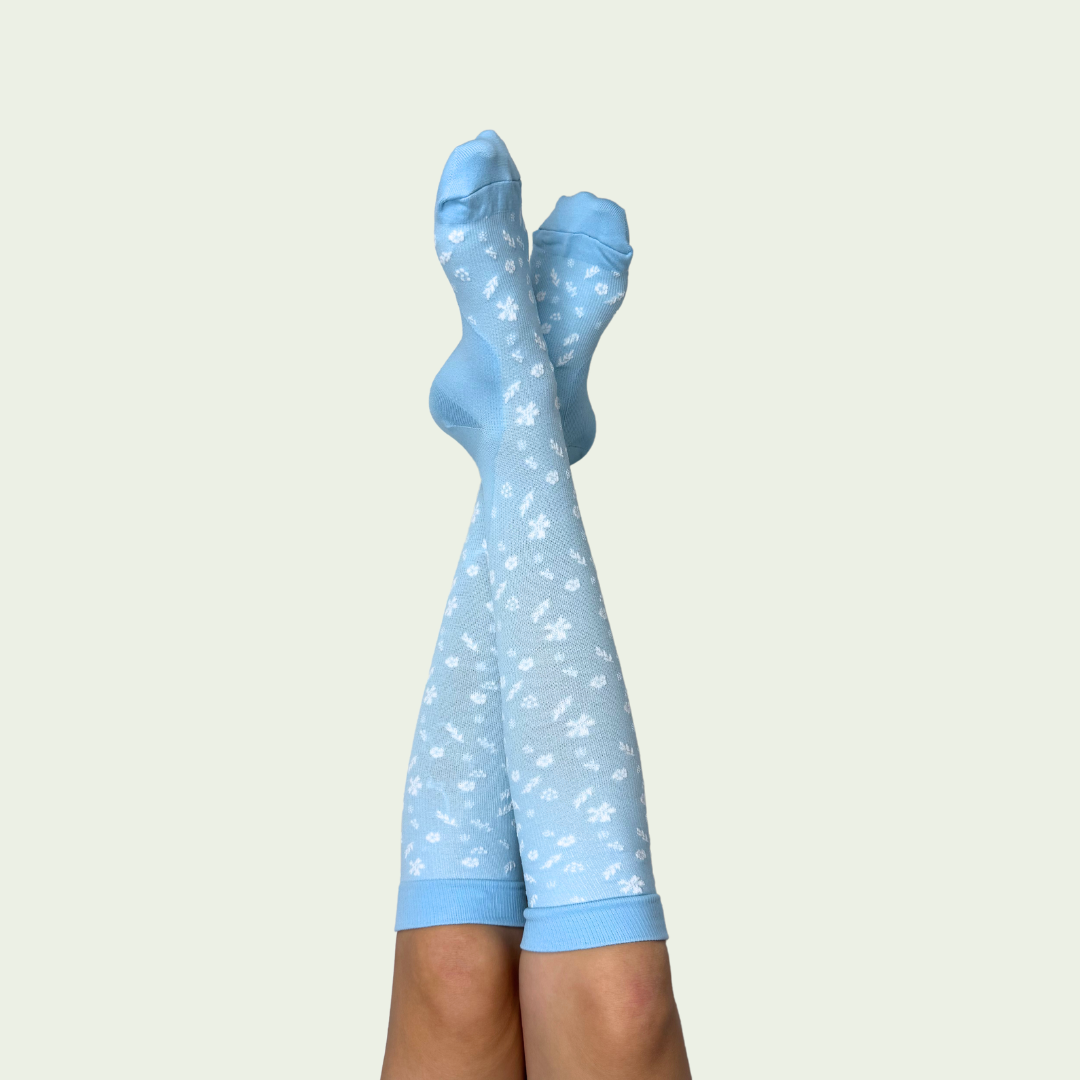 Hellblaue Kompressionsstrümpfe mit weißen Blumen von FlowFit für Schwangere